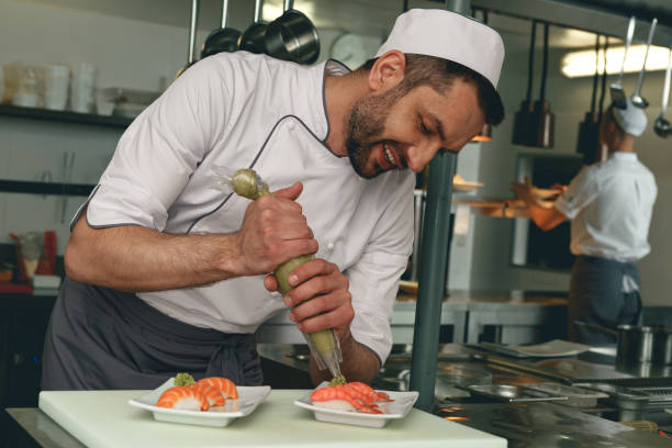 istock Sushi master prepares sushi for serving in modern commercial kitchen 1414955406