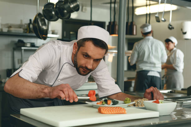 istock Sushi master prepares sushi for serving in modern commercial kitchen 1414956056