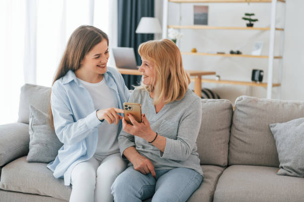istock Using smartphone. Mother and daughter is together at home 1414960068