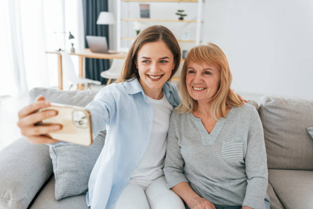 istock Making selfie by using smartphone. Mother and daughter is together at home 1414960086
