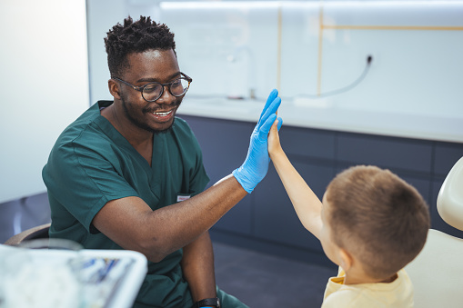 Child visit dentist. Laughing Little boy have five to dentist at dental clinic. Child in stomatological cabinet with dentists. Little boy at regular dental check-up. Little boy at the dentist