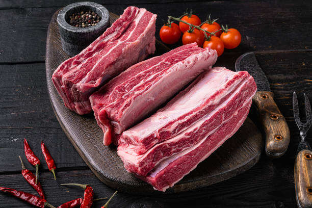 istock Raw Organic Beef Short Ribs, on black wooden table background 1414961245
