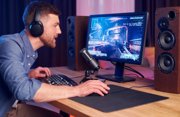 istock Focused on the playing. Man streaming FPS shooter game at home 1414961492