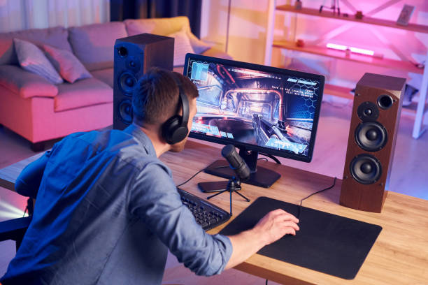 istock Focused on the playing. Man streaming FPS shooter game at home 1414962022