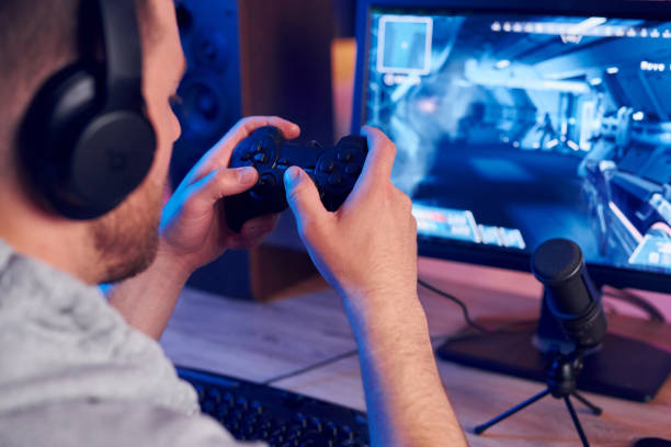 istock Using the joystick. Online streamer playing FPS shooter game at home 1414962109