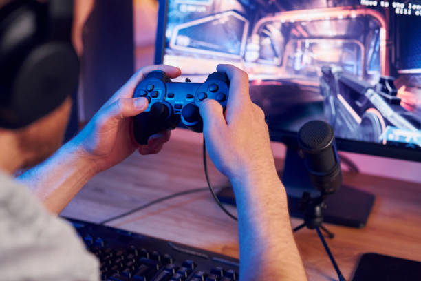 istock Using the joystick. Online streamer playing FPS shooter game at home 1414962180