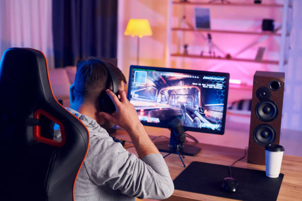 istock Next gen graphics. Online streamer playing FPS shooter game at home 1414962187