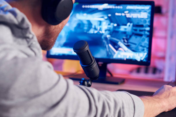 istock Next gen graphics. Online streamer playing FPS shooter game at home 1414962212