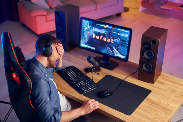 istock Losing the game. Online streamer playing FPS shooter game at home 1414962370
