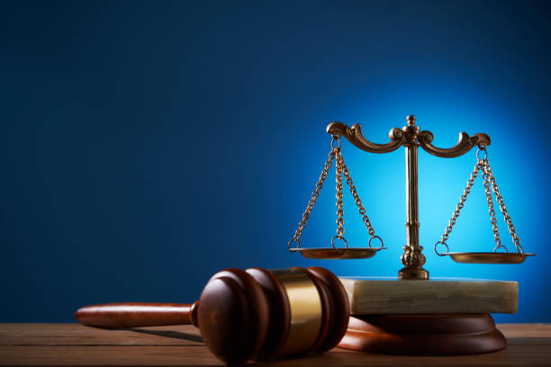 gavel hammer and balance scale against blue background