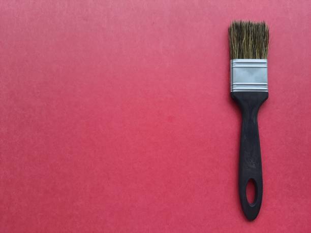 istock Painting: Brush isolated on red background with space for text, top view. 1414964217
