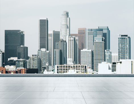 Empty concrete rooftop on the background of a beautiful Los Angeles city skyline at sunset, mock up