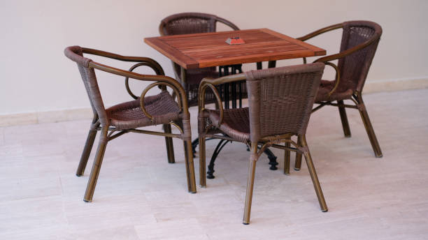 istock Wicker chairs and wooden table outside closeup 1414967191