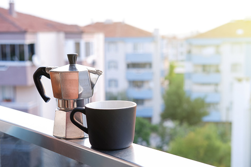 drinking moka pot coffee on the balcony at sunrise, italian culture coffee