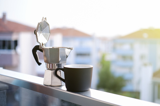 drinking moka pot coffee on the balcony at sunrise, italian culture coffee