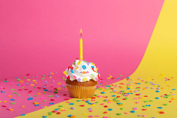 istock Cupcake on a pink-yellow background with candles. 1414968764