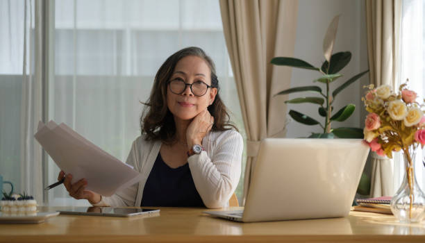 istock Thoughtful senior mature woman watching business training, online webinar on laptop computer while remote working from home. 1414970185