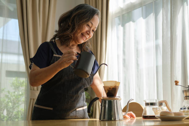 istock Happy middle aged woman preparing coffee for breakfast in comfortable home kitchen. Retirement, Healthy seniors lifestyle. 1414970213