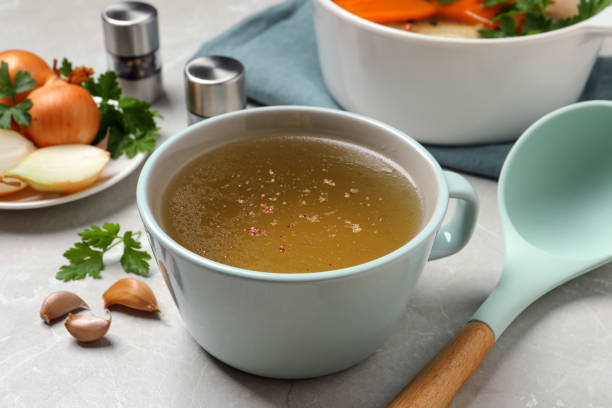 istock Hot delicious bouillon in cup on light grey table 1414970958