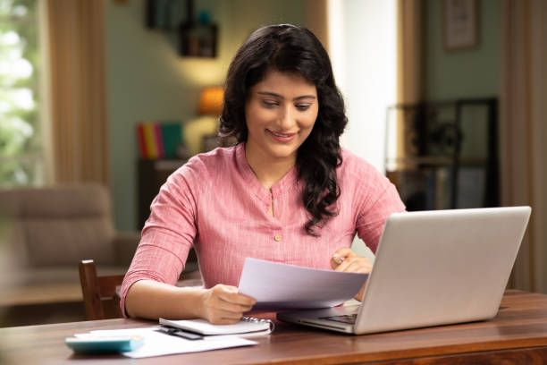 istock indian woman holding reading document sit at table stock photo 1414971092