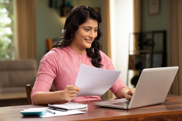 istock indian woman holding reading document sit at table stock photo 1414971180