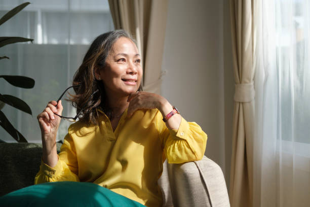istock Middle aged woman resting on comfortable couch, looking away thinking dreaming enjoy stress free peaceful mood wellbeing alone in living room. 1414971209