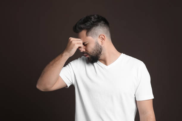 istock Young man suffering from headache on dark background 1414971276