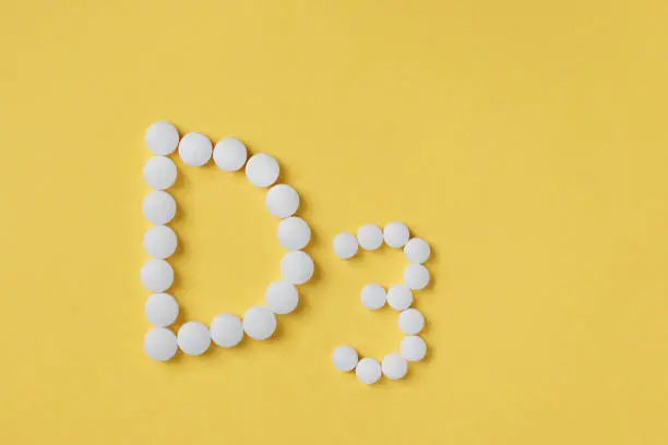 Pills of vitamin D3 on yellow background top view. Concept of vitamin d3. Inscription D3.