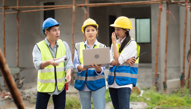 istock Female construction engineer holds computer laptop brainstorming on housing development at a construction site 1414971848