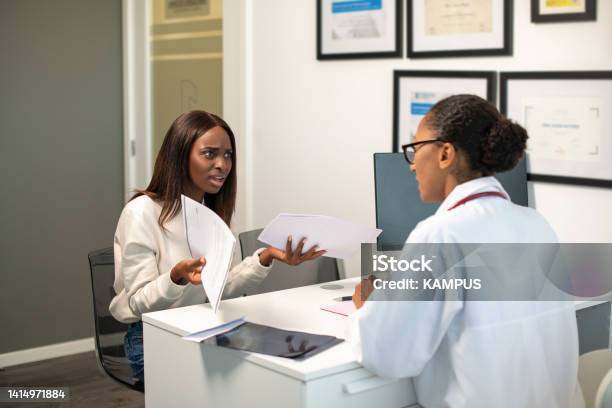 Angry Young Female Patient Arguing With Doctor About Contract Stock Photo - Download Image Now