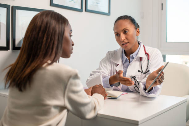 istock Serious doctor explaining diagnosis showing touchpad to patient 1414972484