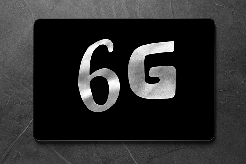6G technology, Internet concept. Number and letter with tablet on grey table, top view