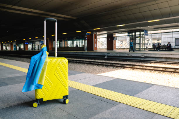 istock yellow valise with ukrainian flag at railway station 1414973094