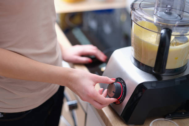 istock Woman turns on mixer with dough in kitchen 1414974665