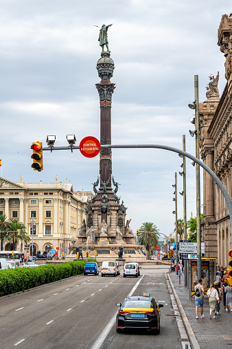 Barcelona, Spain - July 20, 2022: High angle view of the Columbus Monument framed in traffic of the area. The old landmark is a major tourist attraction.