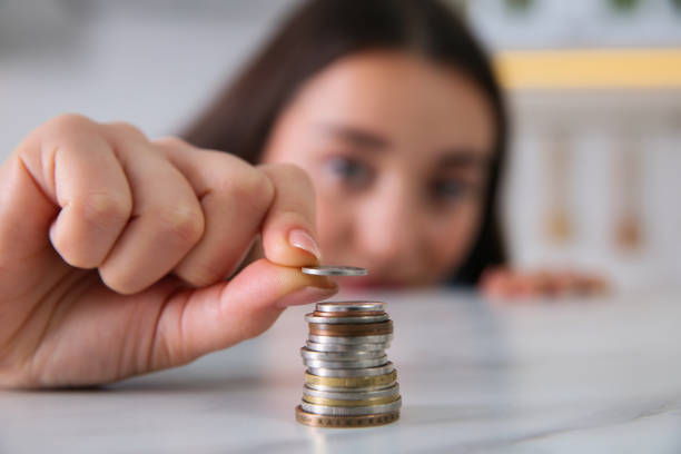 istock Young woman stacking coins at table, focus on hand. Money savings 1414975169