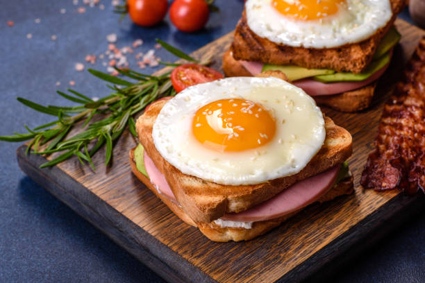 istock Fresh, delicious sandwiches with fried egg, ham, butter, avocado and sesame seeds 1414977756