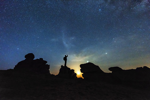 Silhouette photographer standing on boulder before dawn on iceberg beam in China