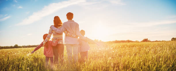 Happy family in the nature together on the evening sunset stock photo
