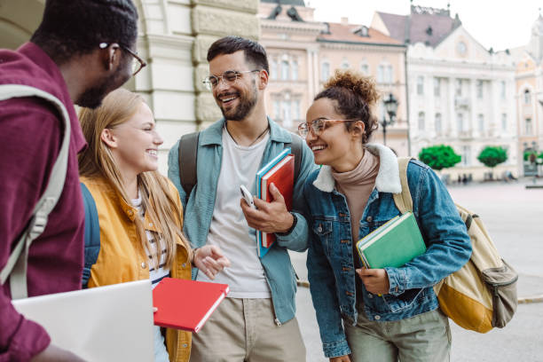 Multi-ethnic group of students talking in front of University stock photo