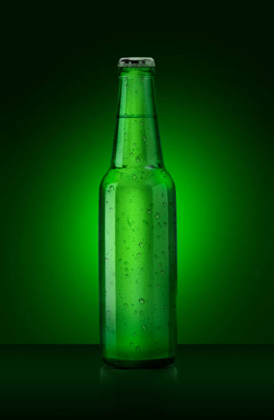 istock 3D render. Single green beer bottle without brand designation. Full glass bottle covered with water drops against green illuminated background. Alcoholic drinks and refreshment concept 1414986141