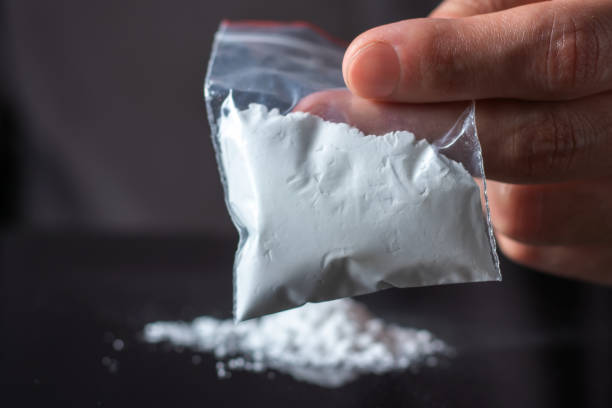 Concept drug addiction. Man hand holds plastic packet or bag with cocaine or another drugs Concept drug addiction. Man hand holds plastic packet or bag with cocaine or another drugs, drug abuse and danger addiction concept. wrongful death stock pictures, royalty-free photos & images