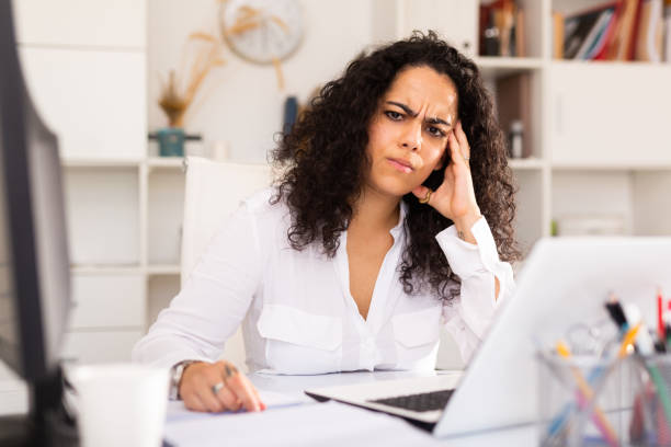 istock Frustrated woman working alone in office 1414987080