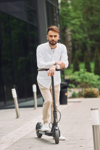 istock Posing for a camera. Stylish man is with his scooter outdoors at daytime 1414987125