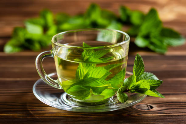 istock Cup of mint tea and a bunch of mint on the table 1414987984