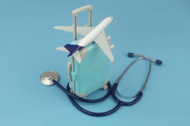 istock Airplane on travel suitcase and stethoscope on blue background. 1414988057