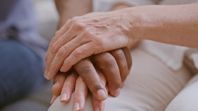 Closeup of hand holding to show support, care and friendship to a person in need. Caring and loving gesture of people looking out for each other. Fingers together for comfort, love and hope