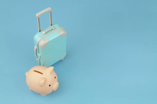 istock Piggy bank and blue suitcase on blue background. 1414988426