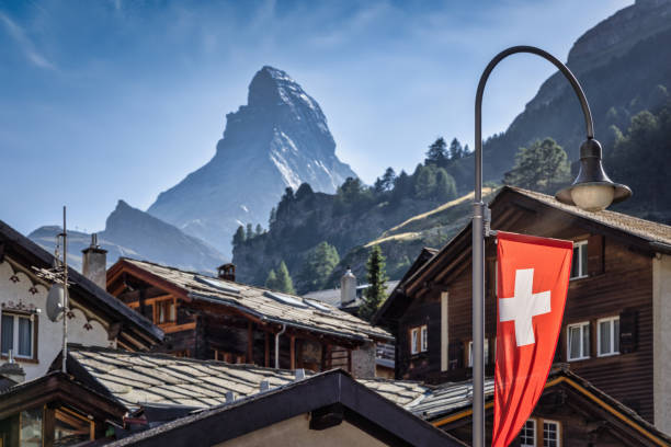 ciudad de zermatt con vista al pico matterhorn y bandera suiza - switzerland fotografías e imágenes de stock