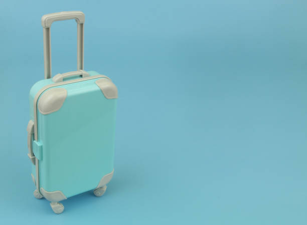istock Travel suitcase or bag on blue background with copy space for text. 1414989992